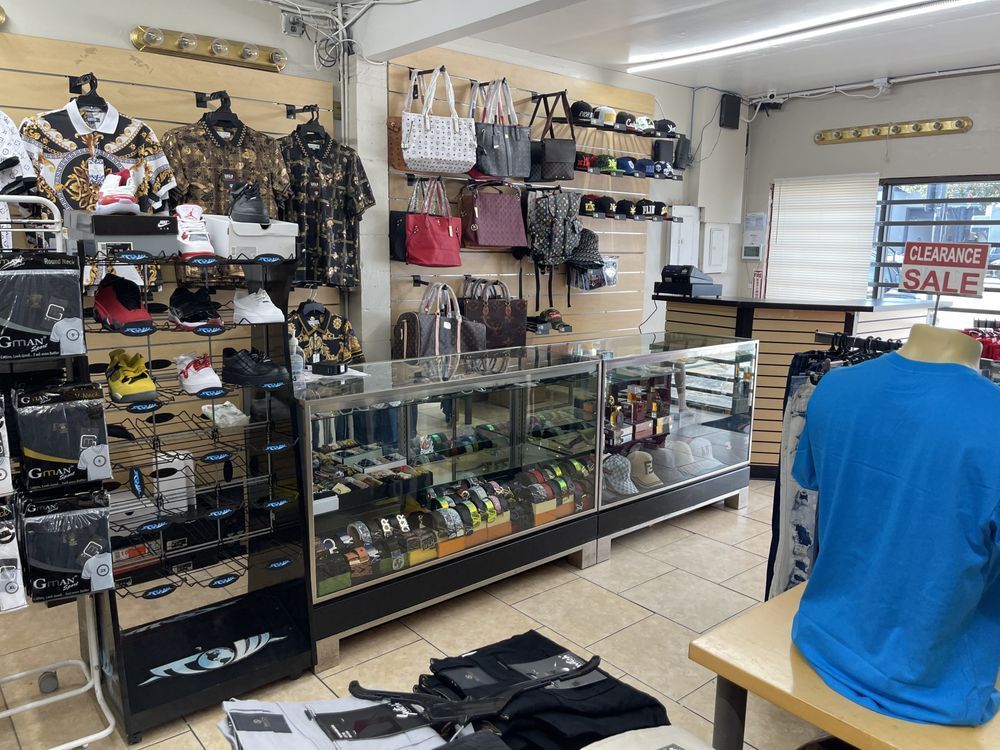 Inside a retail clothing store, merchandise is displayed on racks and shelves.