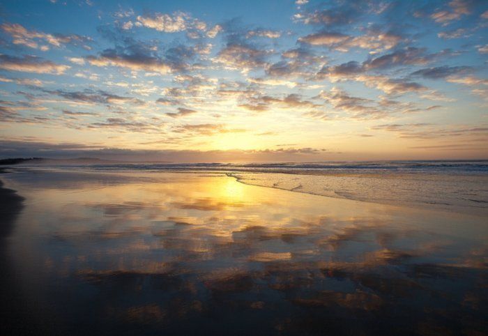 A Sunset Over A Beach With A Reflection Of The Sun In The Water — Sal's Excavations In Nowra, NSW