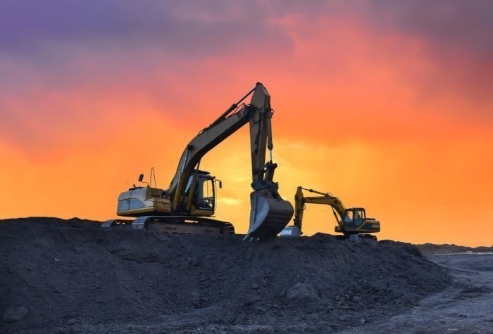 Two Excavators Are Working On A Construction Site At Sunset — Sal's Excavations In St. Georges Basin, NSW