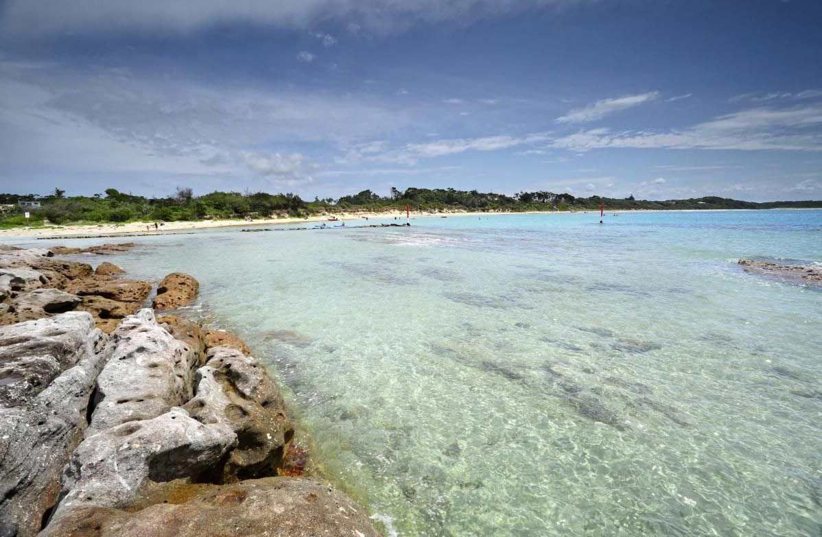 A Beach With Rocks In The Foreground And A Body Of Water In The Background — Sal's Excavations In Jervis Bay, NSW