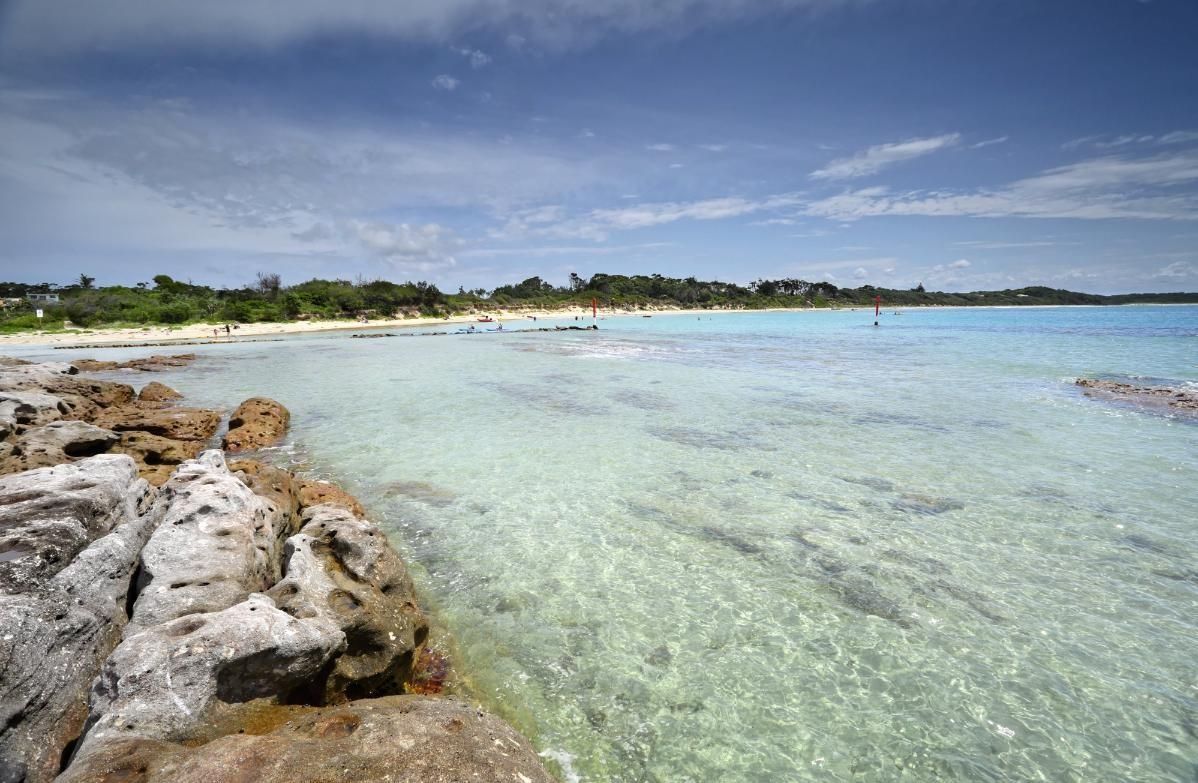 A Large Body Of Water With Rocks In The Foreground — Sal's Excavations In Jervis Bay, NSW