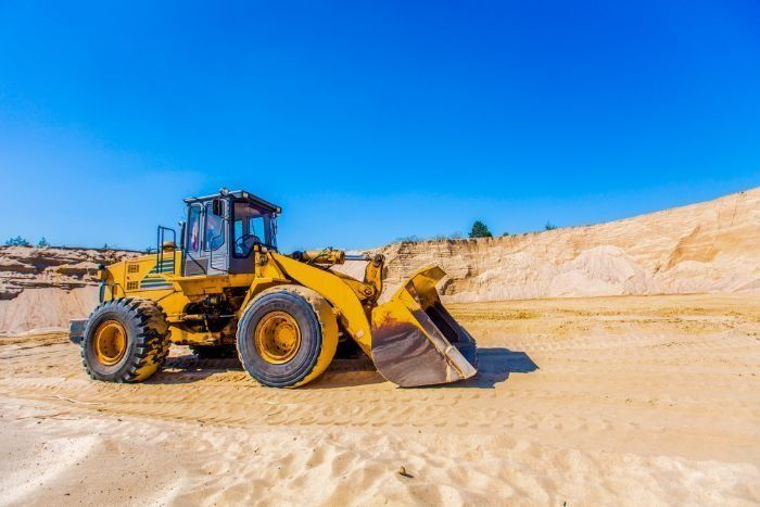 A Yellow Bulldozer Is Sitting In The Middle Of A Sandy Field — Sal's Excavations In Vincentia, NSW