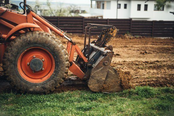 A Bulldozer Is Moving Dirt In A Grassy Field — Sal's Excavations In Nowra, NSW