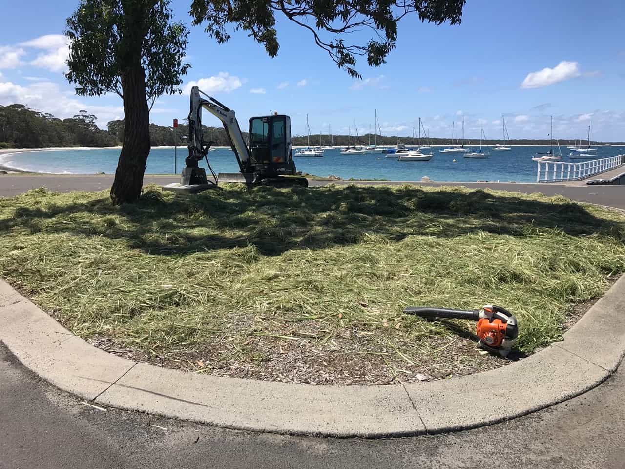 A Lawn Mower Sitting On The Ground In Front Of A Body Of Water — Sal's Excavations In Jervis Bay, NSW
