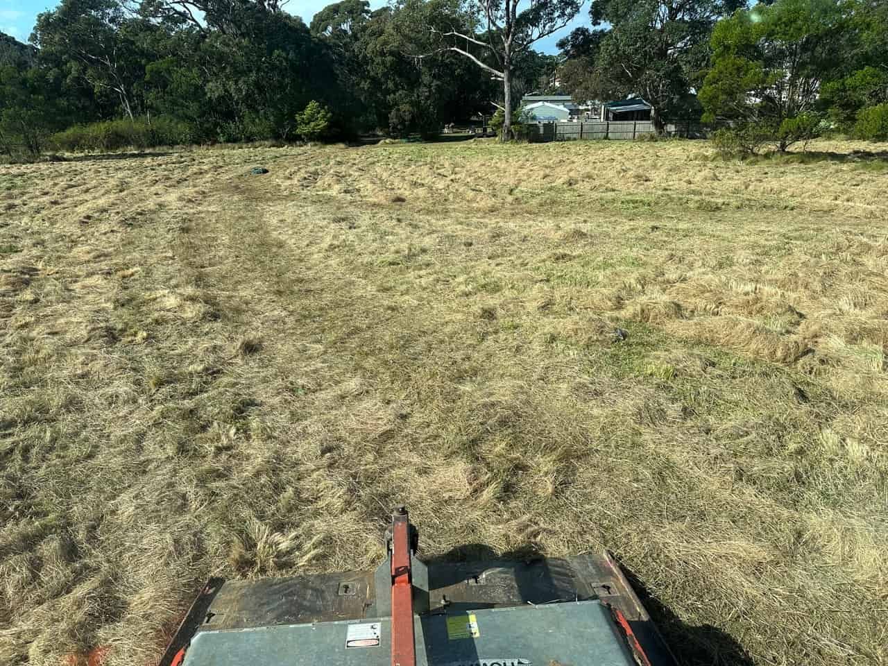 A Lawn Mower Cutting Grass In A Field — Sal's Excavations In Falls Creek, NSW