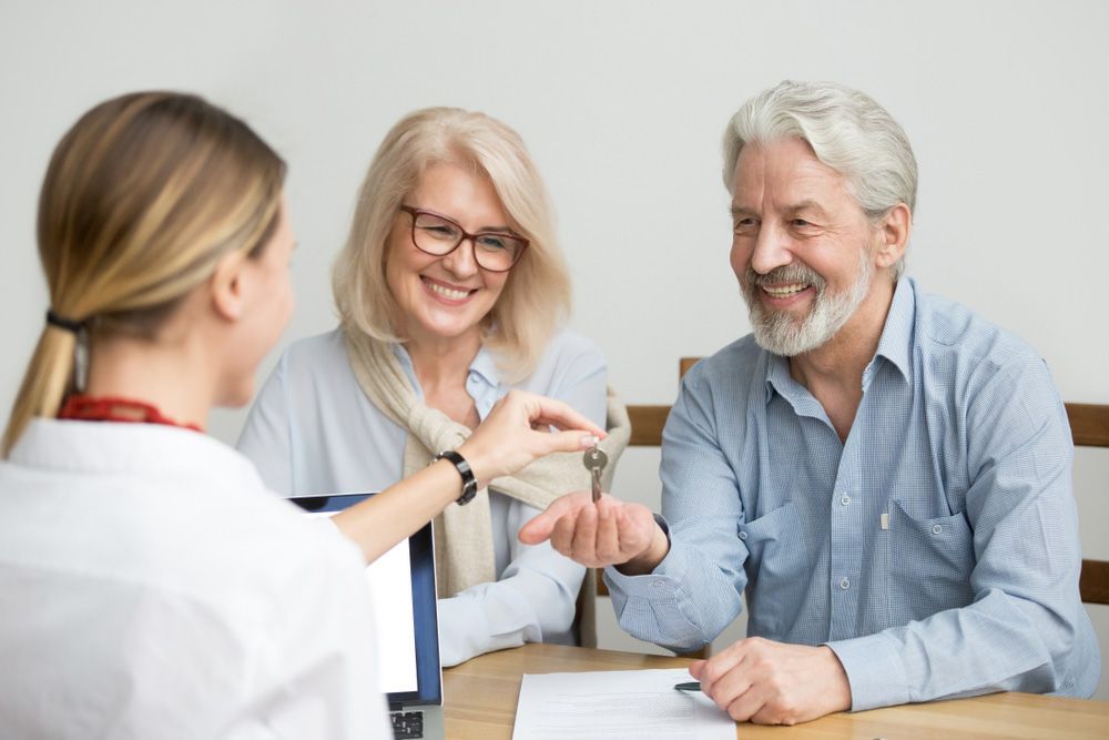 Happy senior couple get keys to own home from realtor — Dentures in Port Stephens, NSW