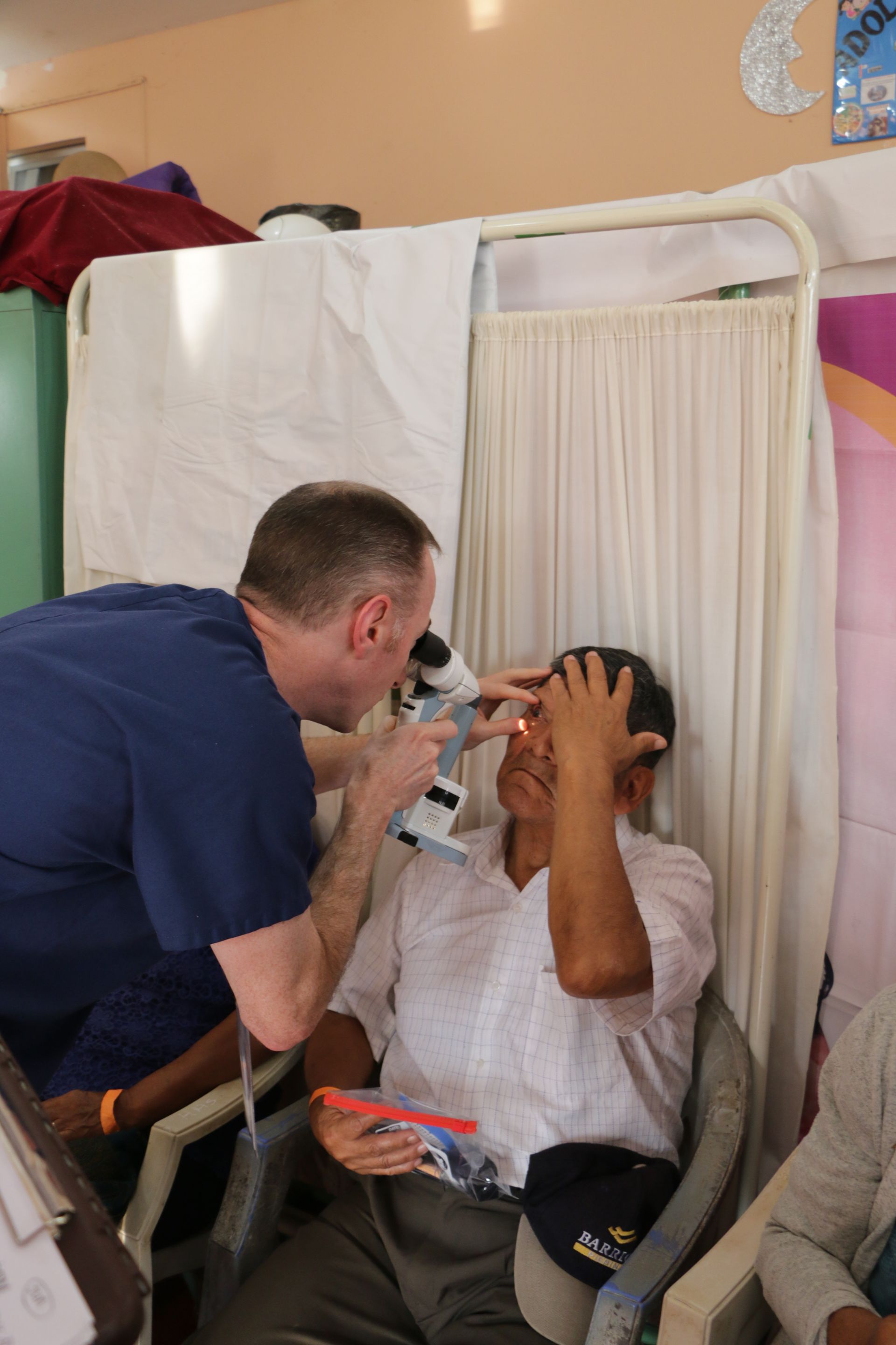 A doctor is examining a patient 's eye with a microscope.