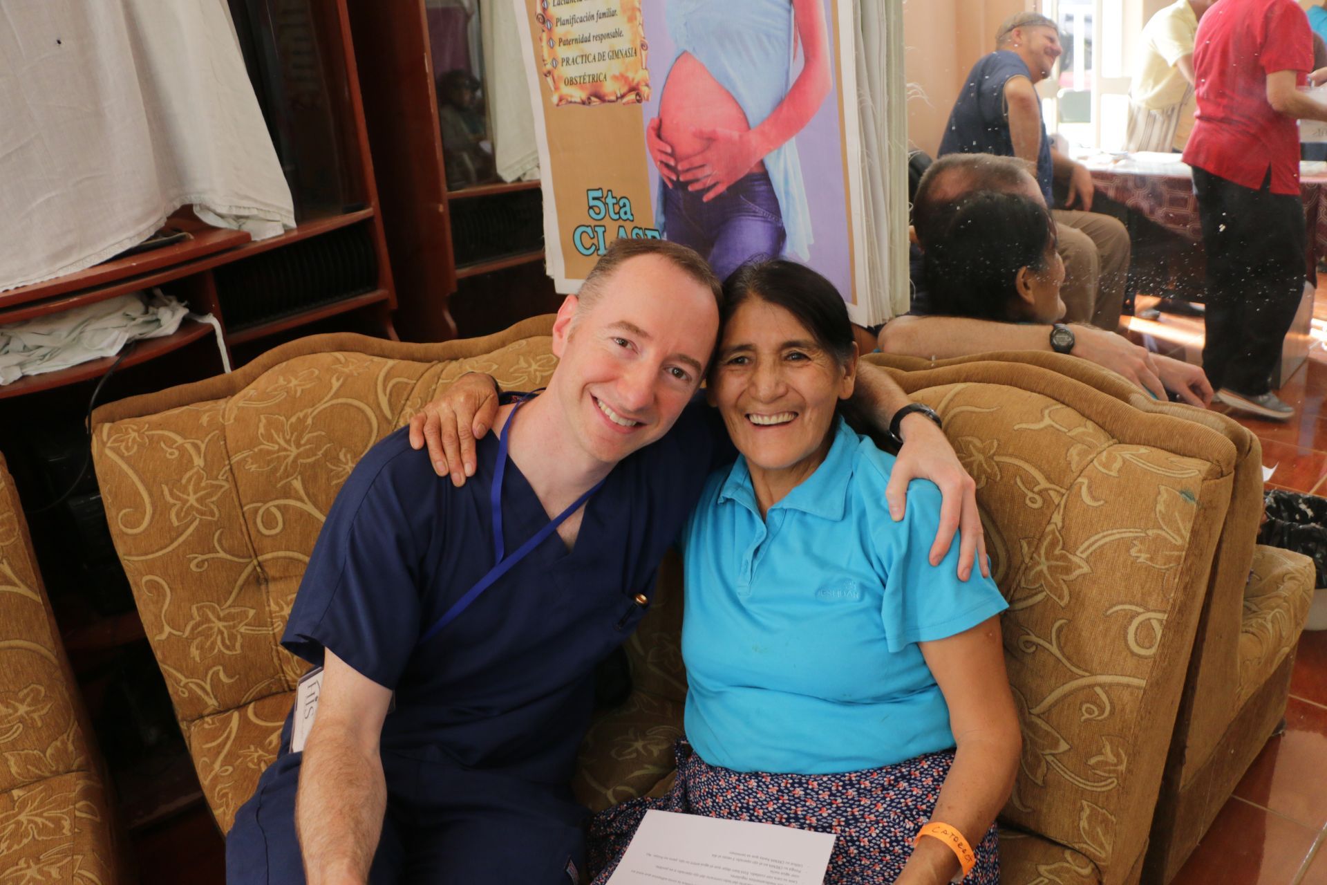 A man and a woman are posing for a picture while sitting on a couch.