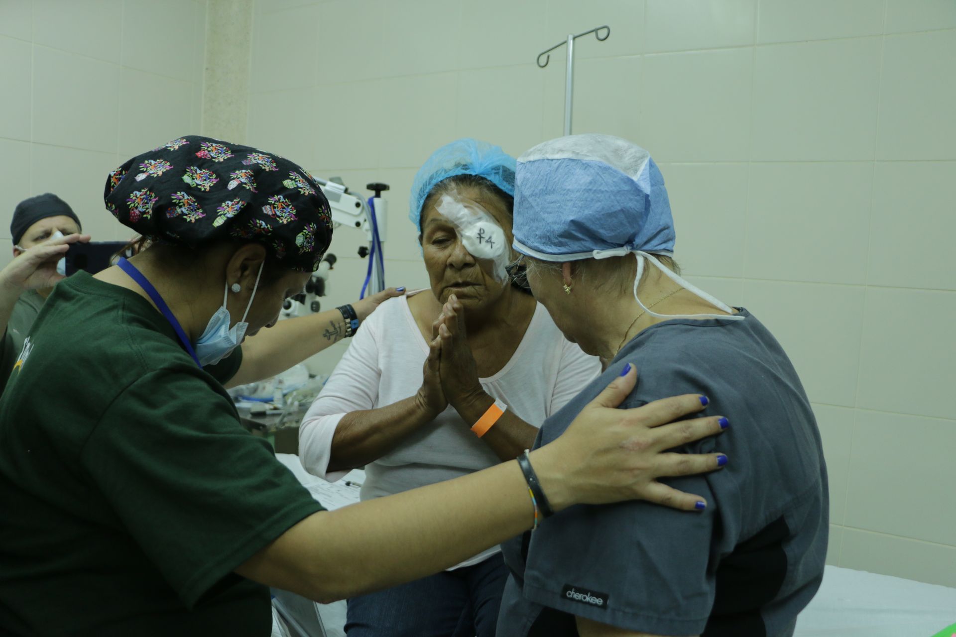 A group of doctors are talking to a patient in an operating room.