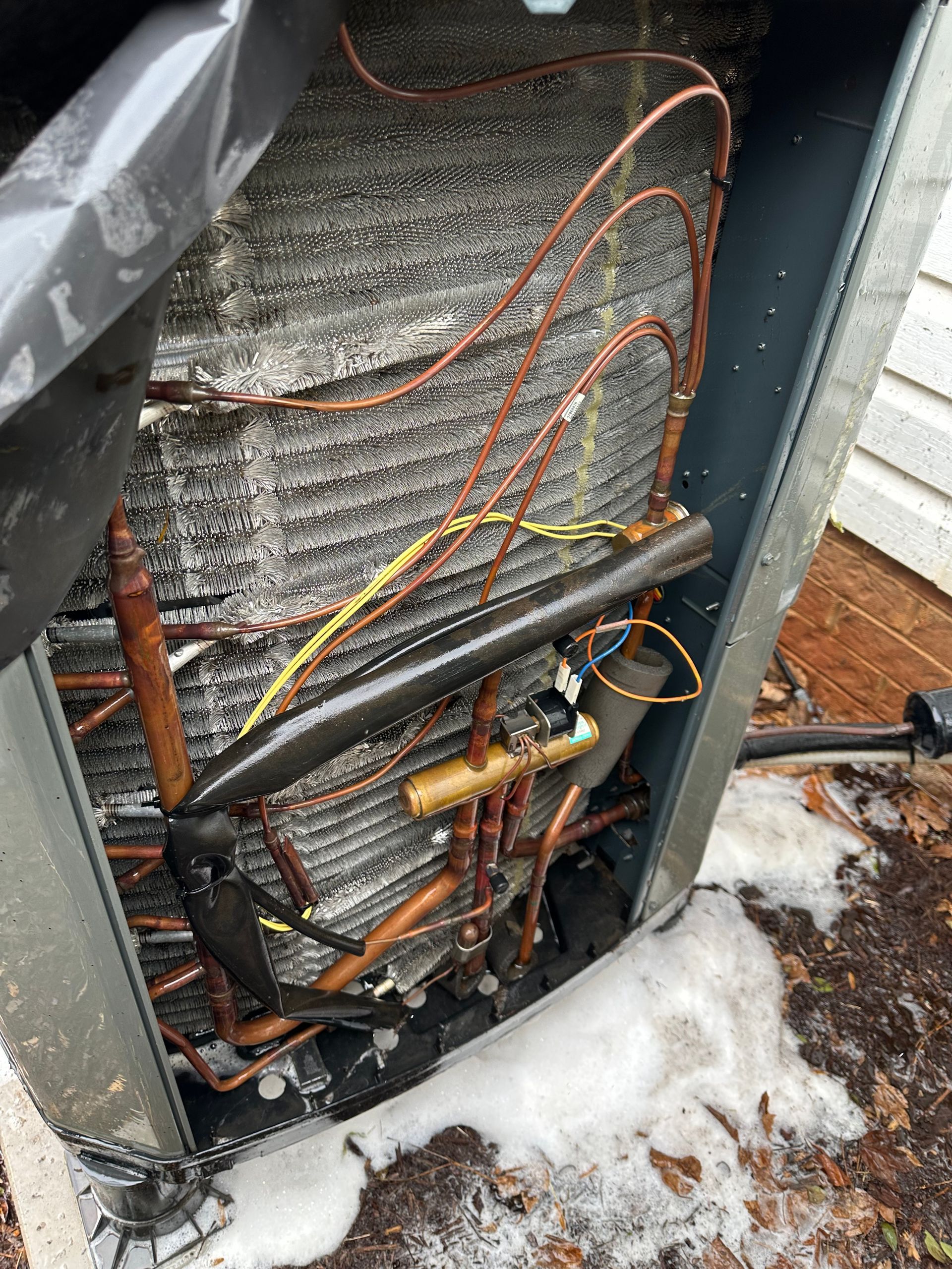 The inside of an air conditioner with a lot of wires coming out of it.