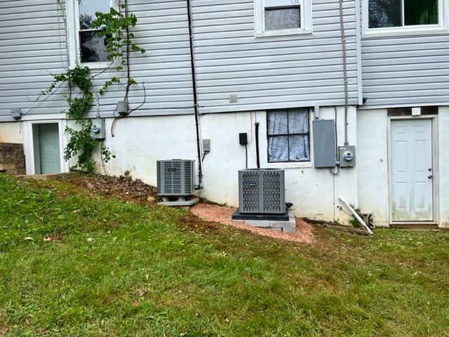 A house with two air conditioners on the side of it.