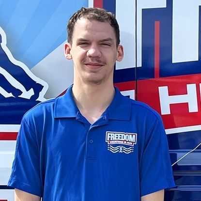 A man wearing a blue shirt with the word freedom on it