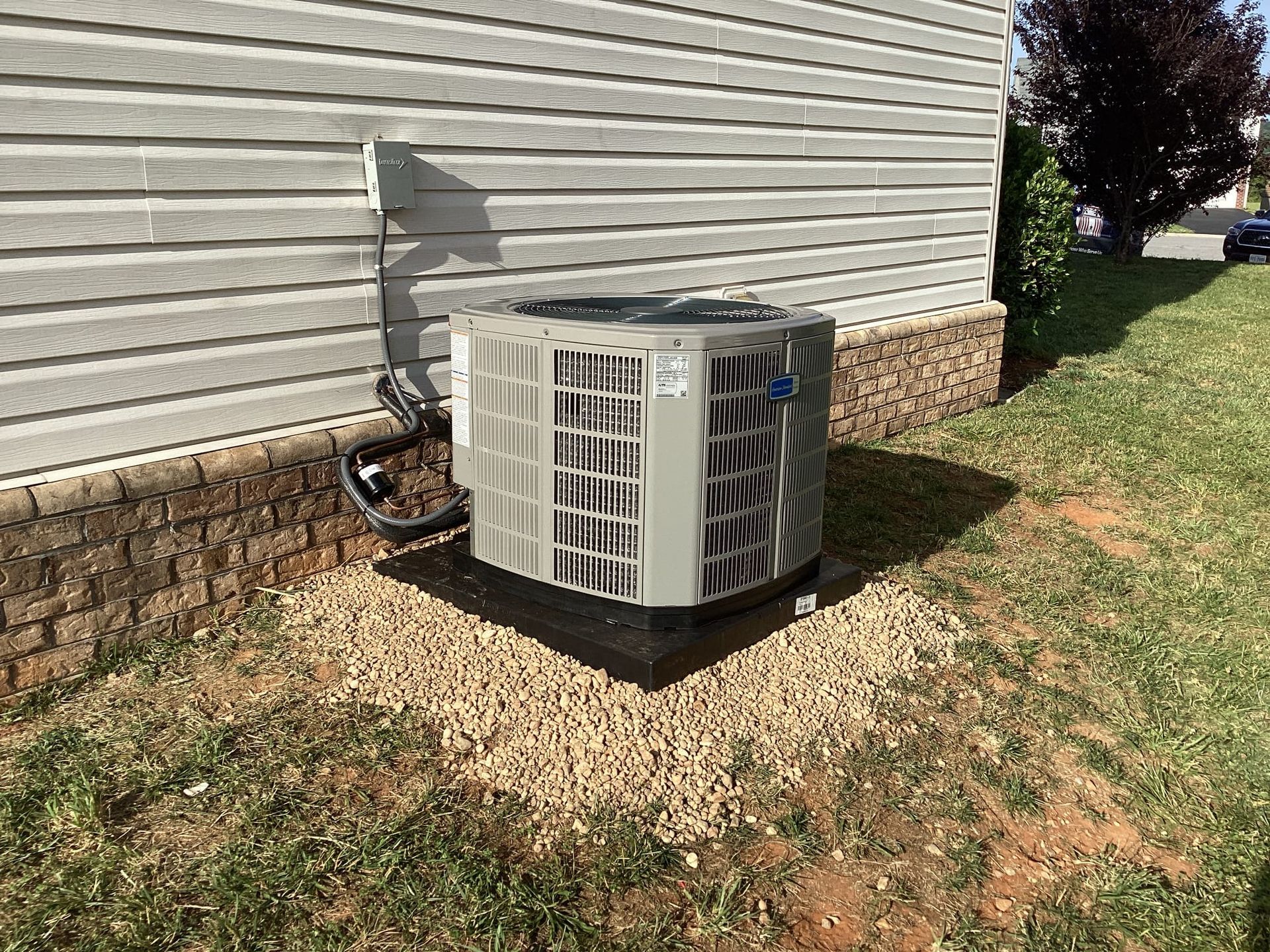 An air conditioner is sitting on the side of a house.