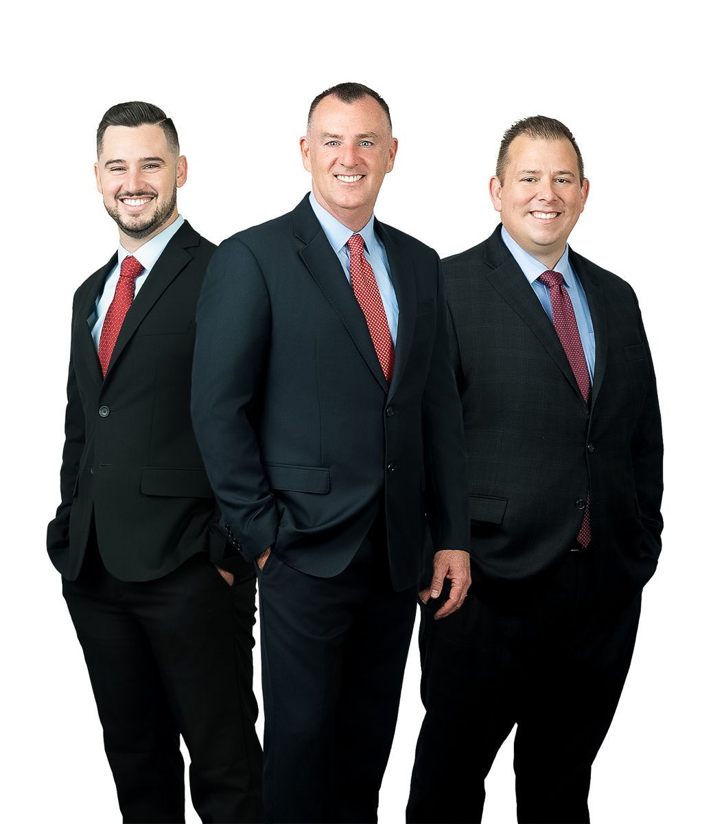 Three men in suits and ties are standing next to each other on a white background.