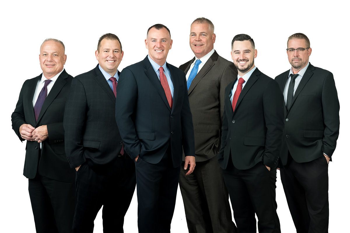 A group of men in suits and ties are posing for a picture.