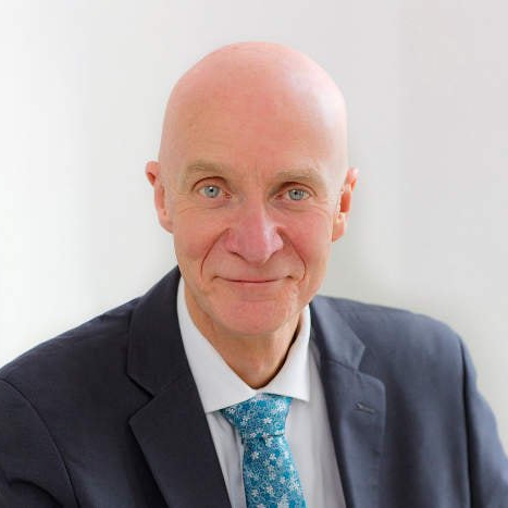 a man in a suit and tie is smiling for the camera .