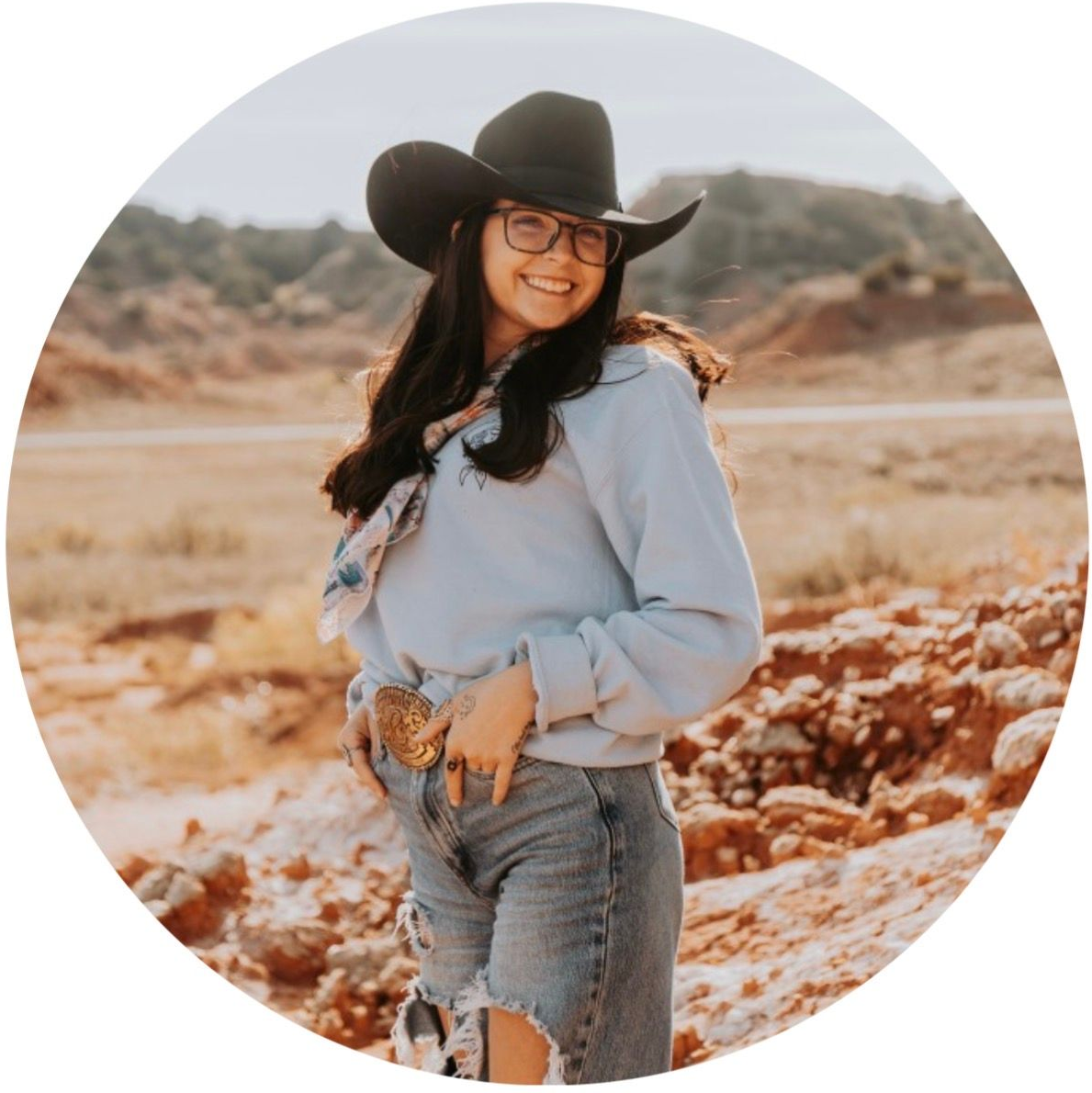 Woman smiling beside a picture of her with dogs in a backyard.
