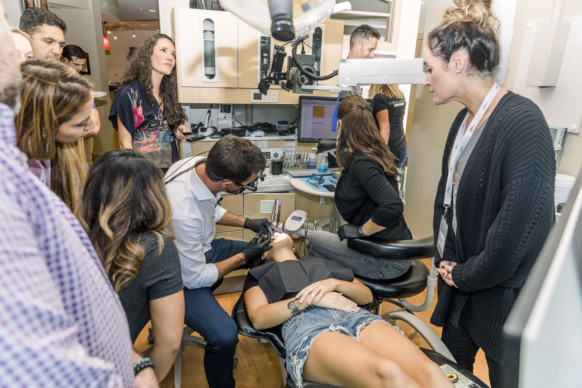 A group of people looking at a woman in a dental chair