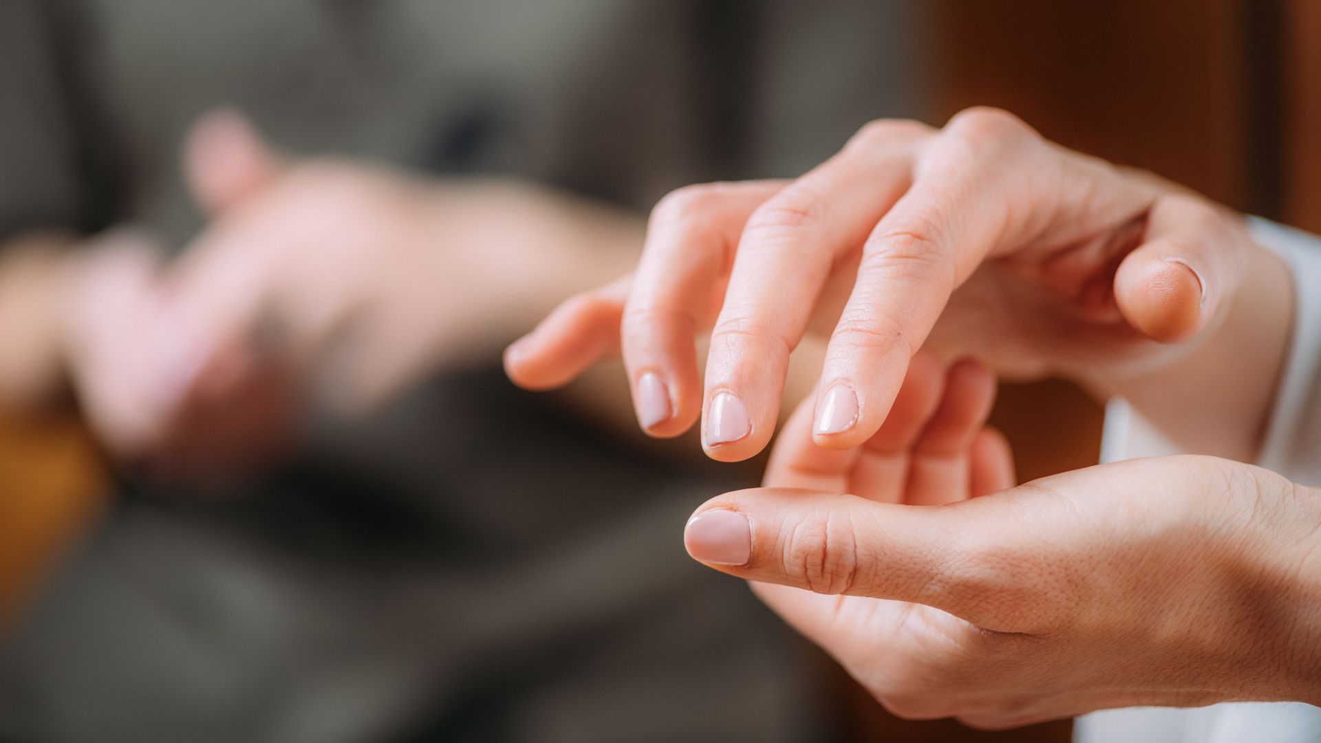 A man is putting a wedding ring on a woman 's finger.