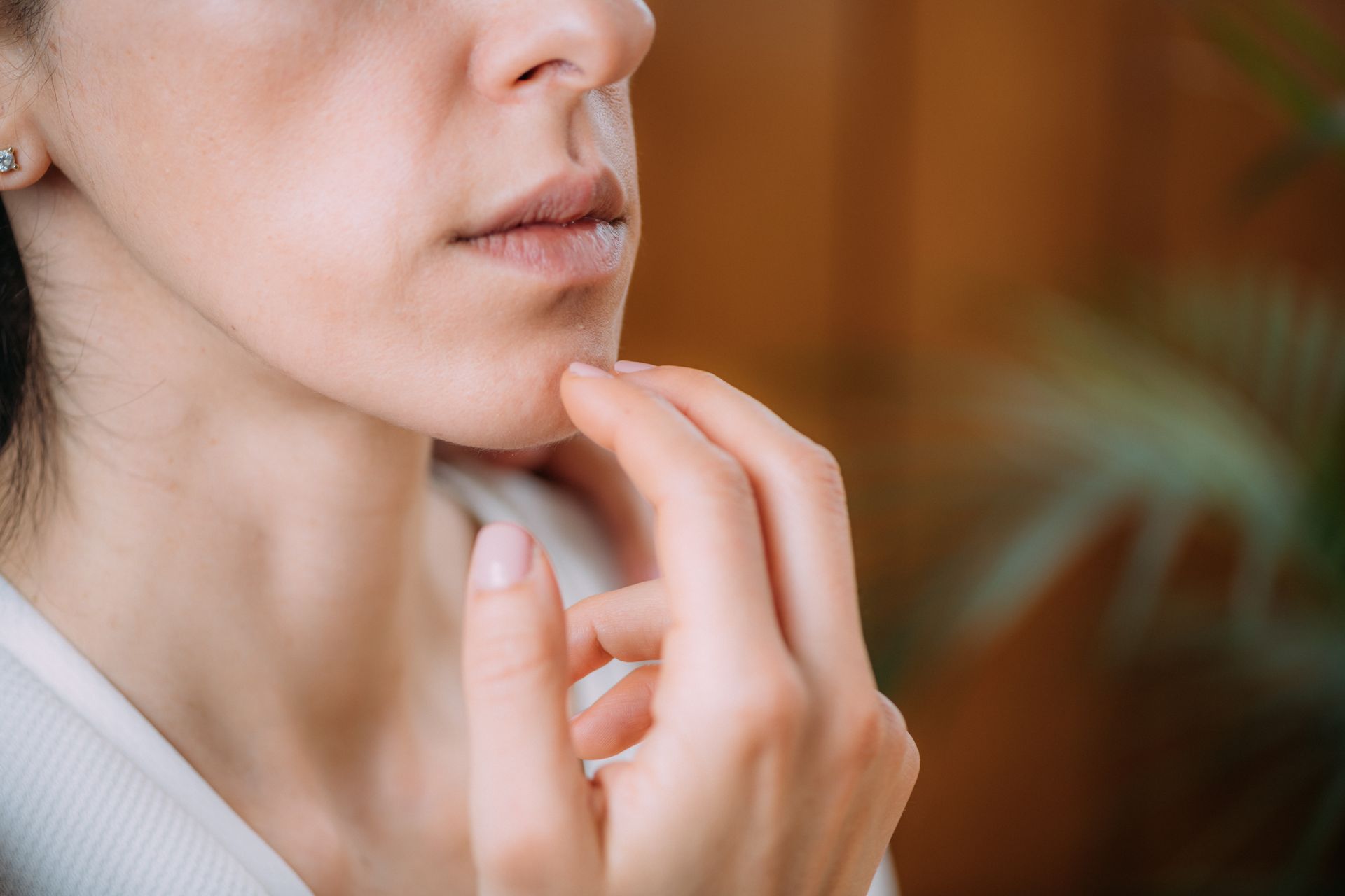 A close up of a woman 's face with her hands on her chin.