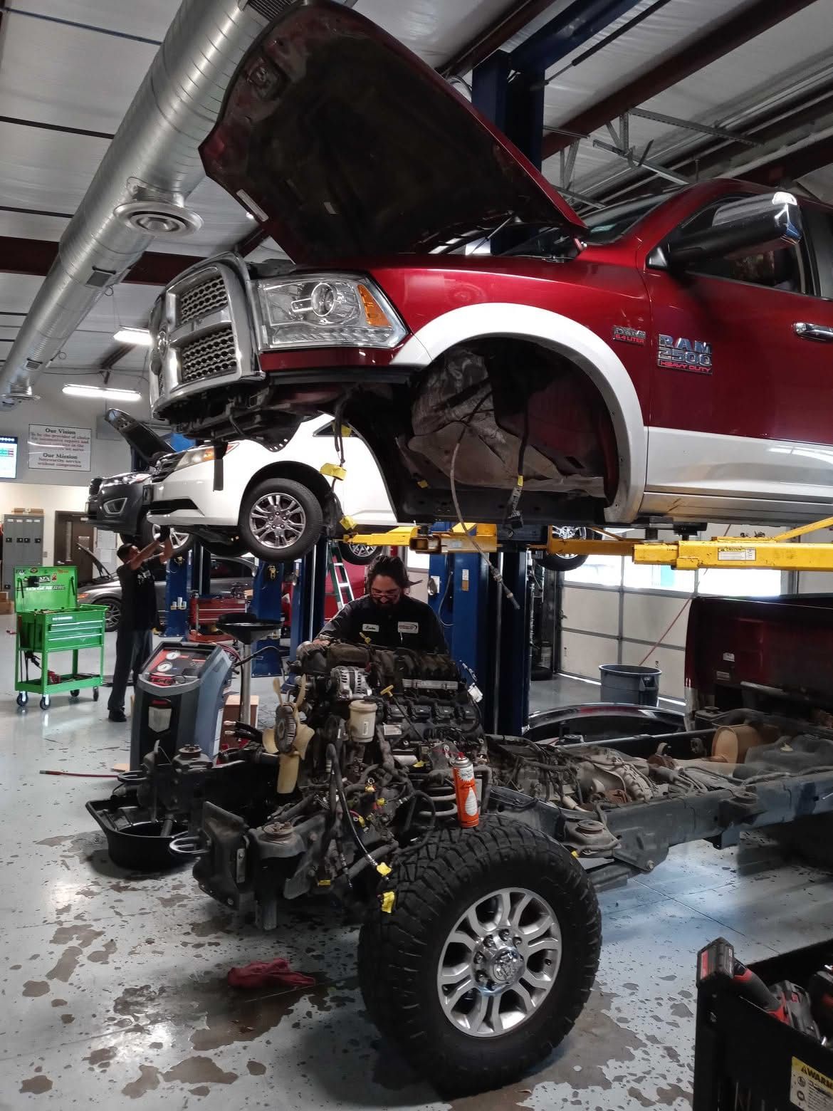 Technician Working on Engine Repair with Vehicle on Lift | Elite Auto Care