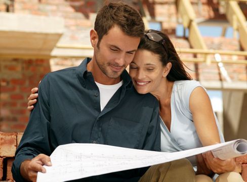 Happy couple looking at plans by a Toowoomba building contractor