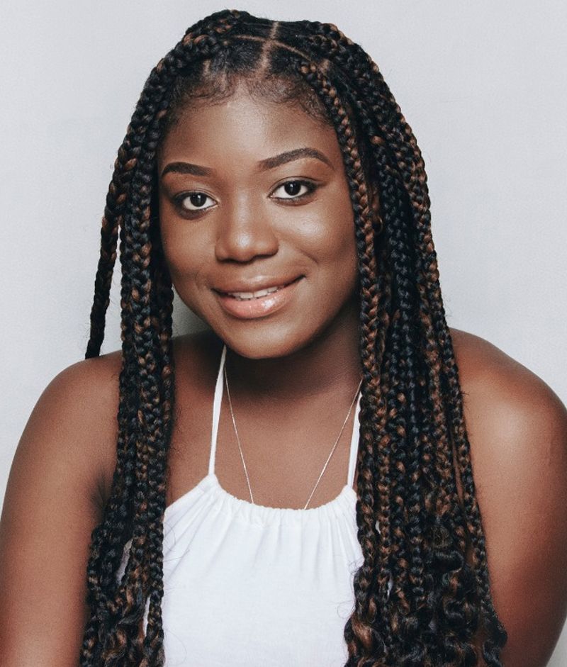 A Woman With Braids Is Wearing A White Tank Top