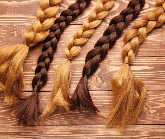 Three Braids Of Different Colors Are Sitting On A Wooden Table