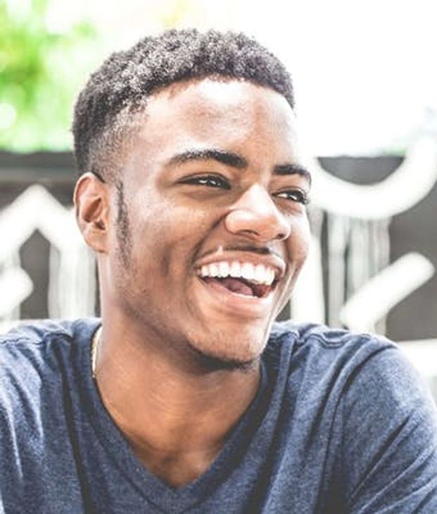 A Young Man in A Blue Shirt Is Smiling