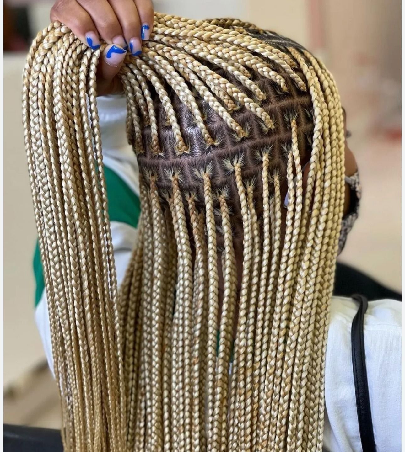 Close-up of blonde box braids on a person's head, showing the intricate braiding pattern and scalp.