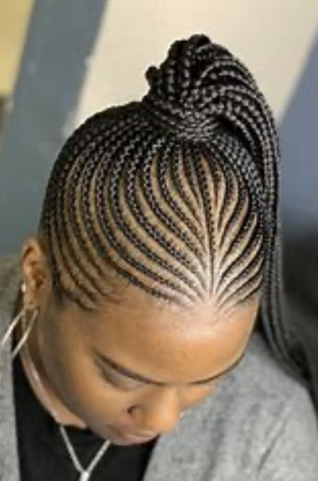 Close-up of cornrow braids styled into a high ponytail. Braids feature a fan-like pattern on the forehead.