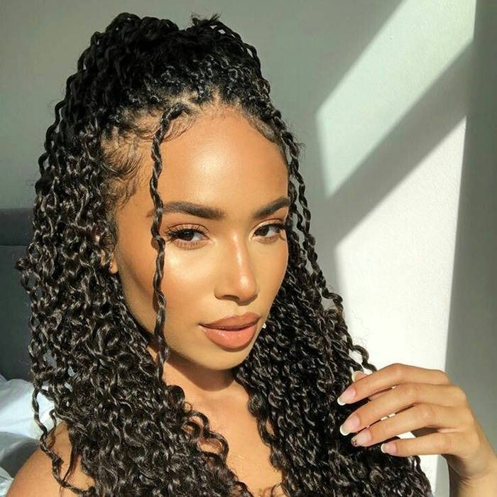 Woman with long, twisted braids; sunlight illuminates her face.