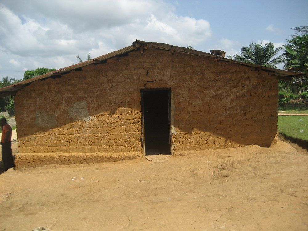 A woman stands in front of a brick building
