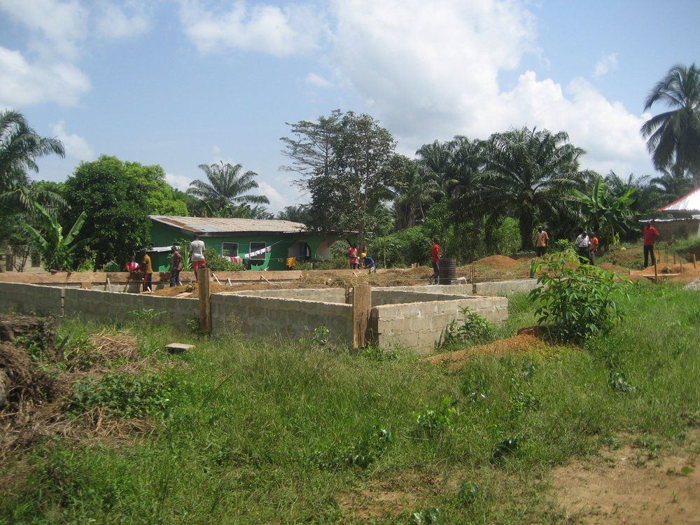 A group of people are working on a building in a field