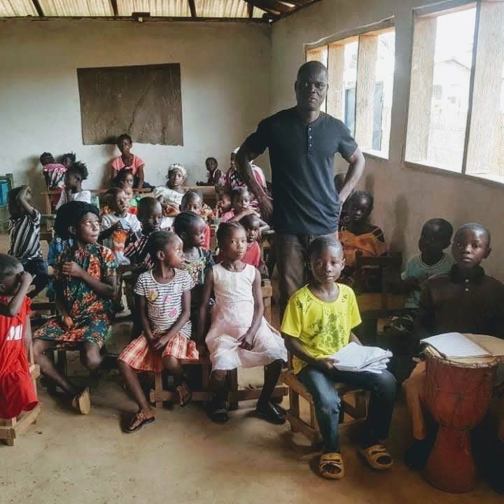 A man is standing in front of a group of children