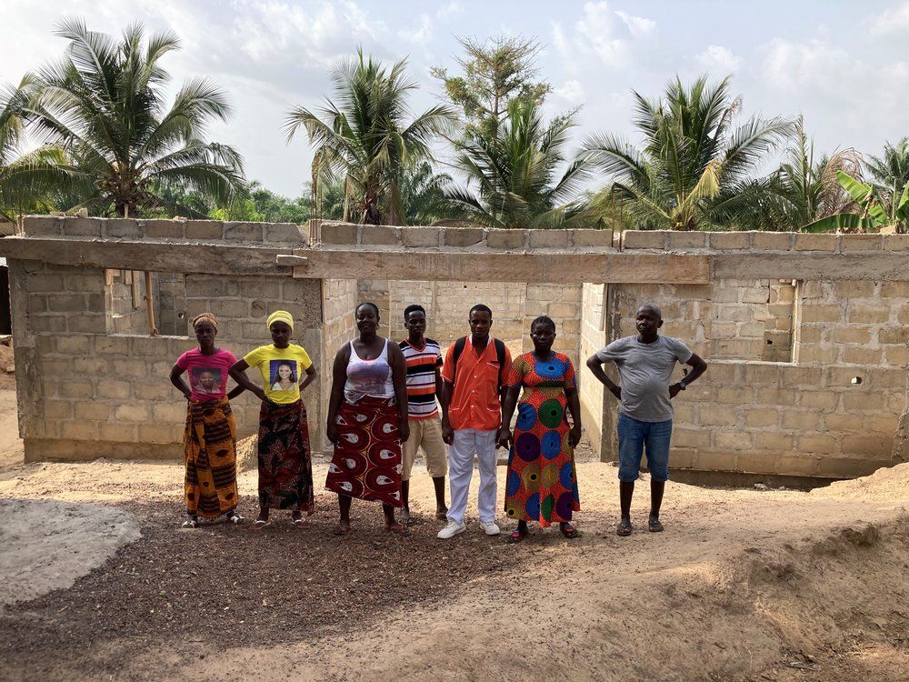 A group of people are standing in front of a building under construction.