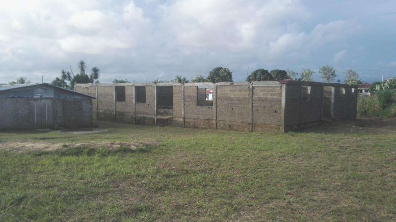 A building is being built in the middle of a grassy field.