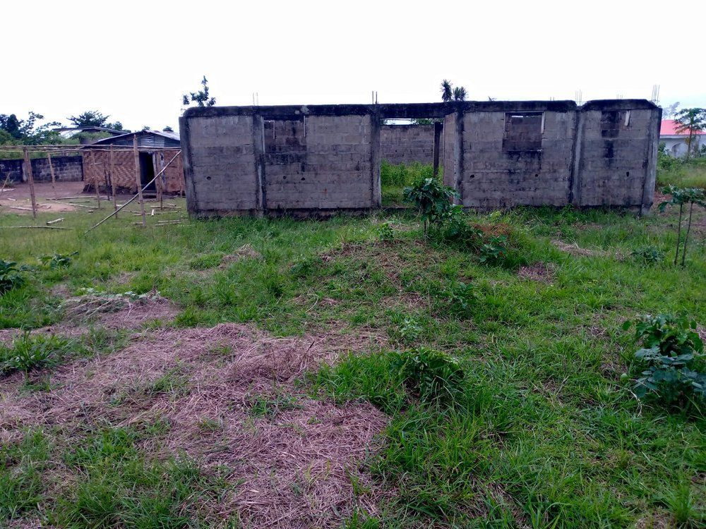 A concrete building is sitting in the middle of a grassy field.