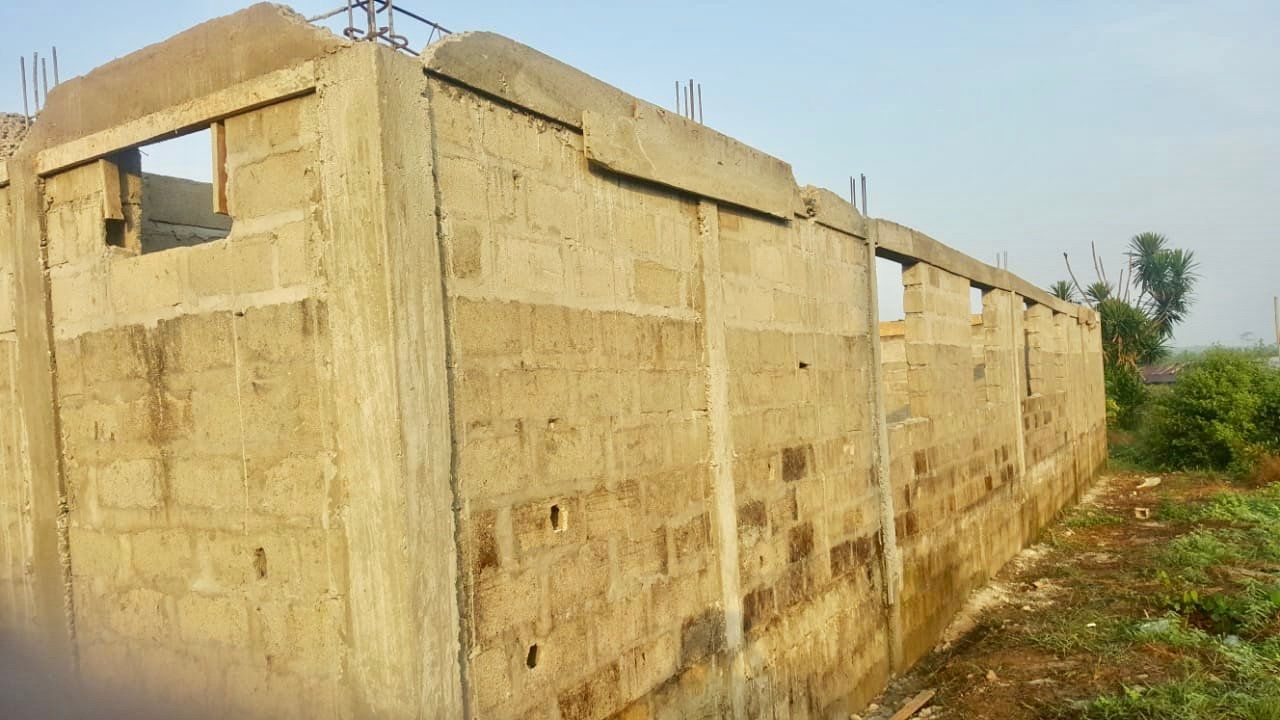 A large concrete wall is being built in a field.