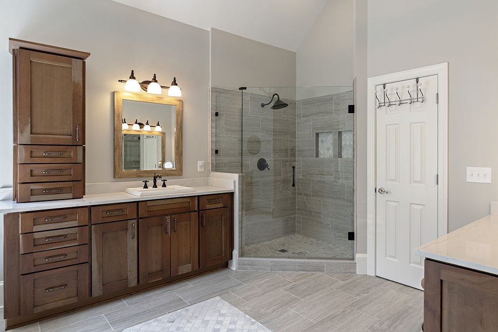 Bathroom with dark wood cabinets, a glass shower, and a white door.