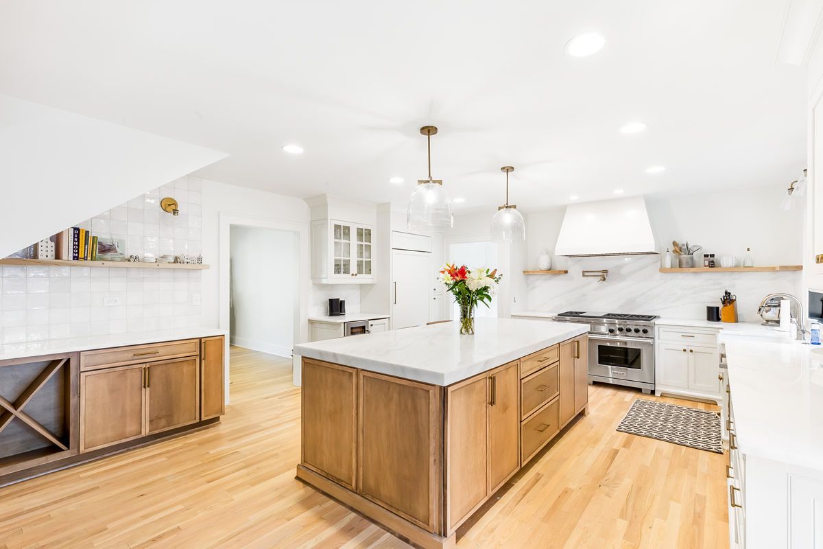 Bright kitchen with light wood cabinets, white countertops, and an island.