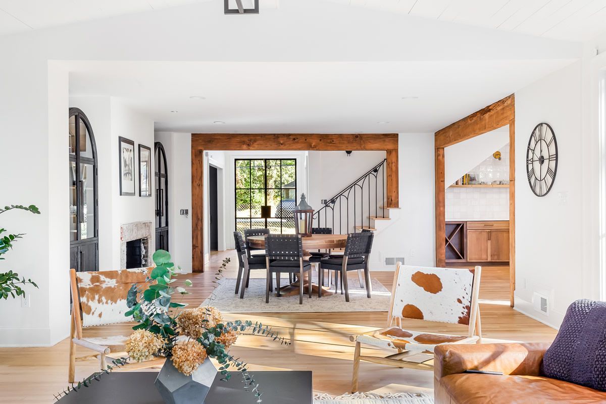 Open-concept living space with a dining area, hardwood floors, and cowhide chairs.