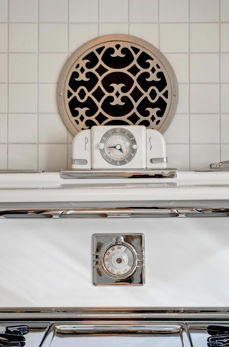 White oven with clock and decorative vent.