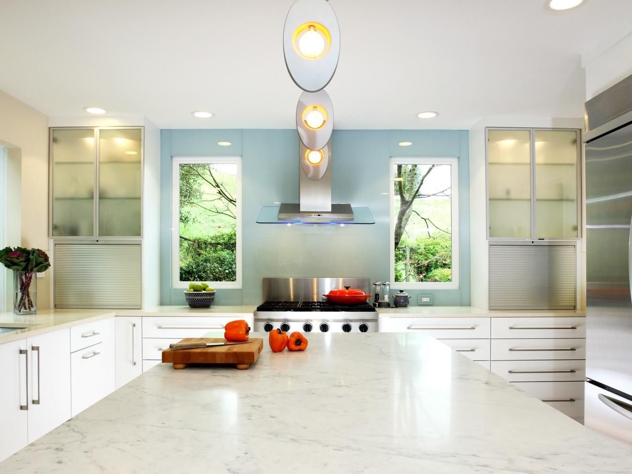 Bright modern kitchen with white cabinets, blue backsplash, and central island.