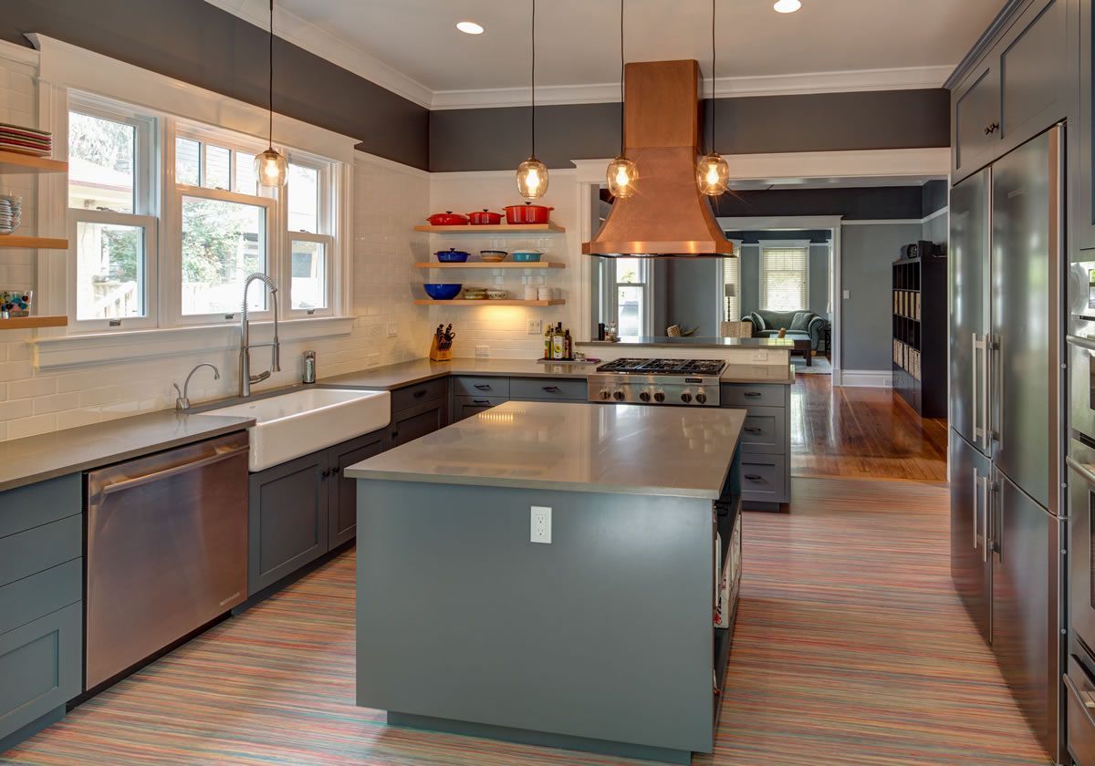 Modern kitchen with gray cabinets, island, and copper range hood.