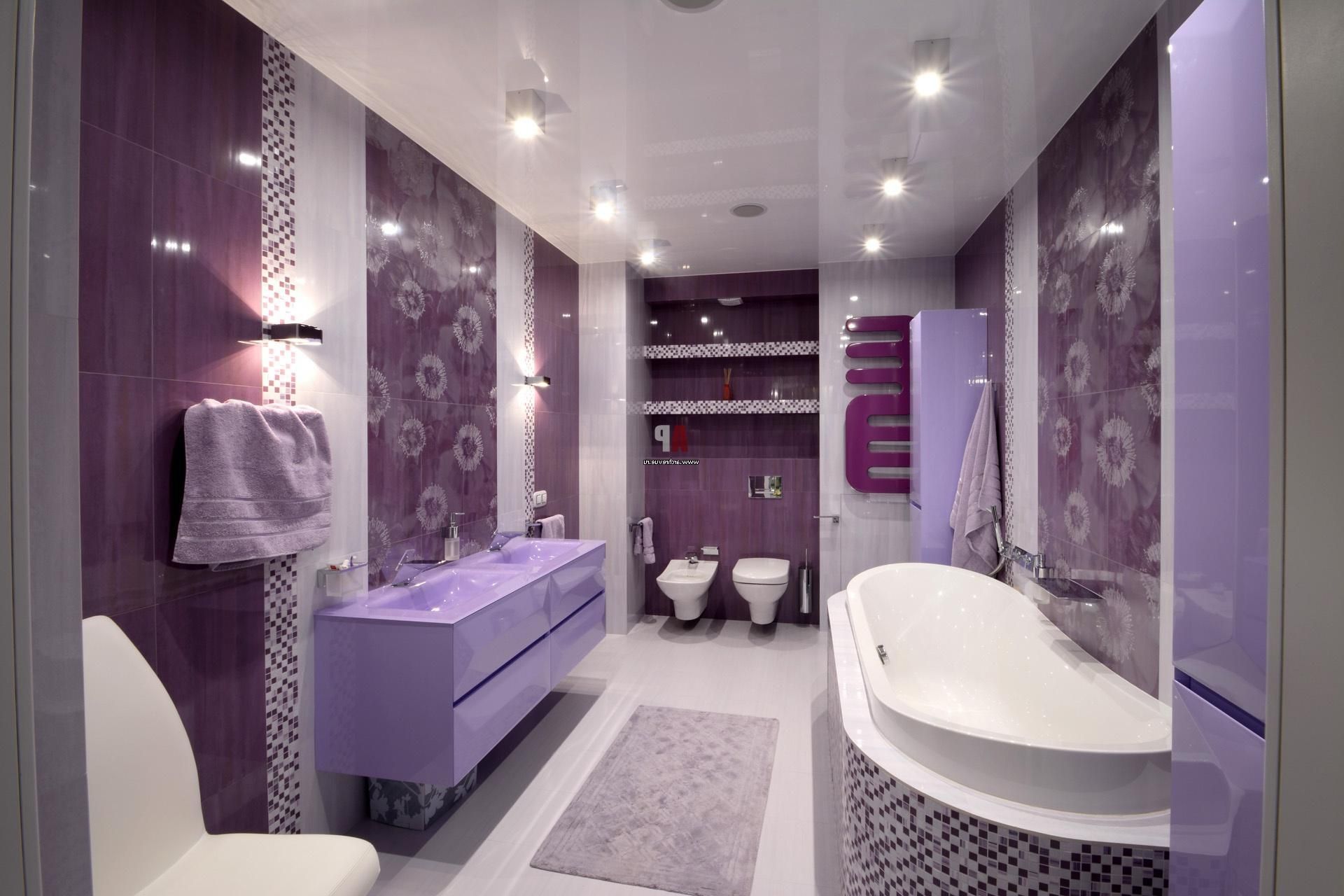 Purple bathroom with tiled walls, bathtub, vanity, and toilet; overhead lighting.