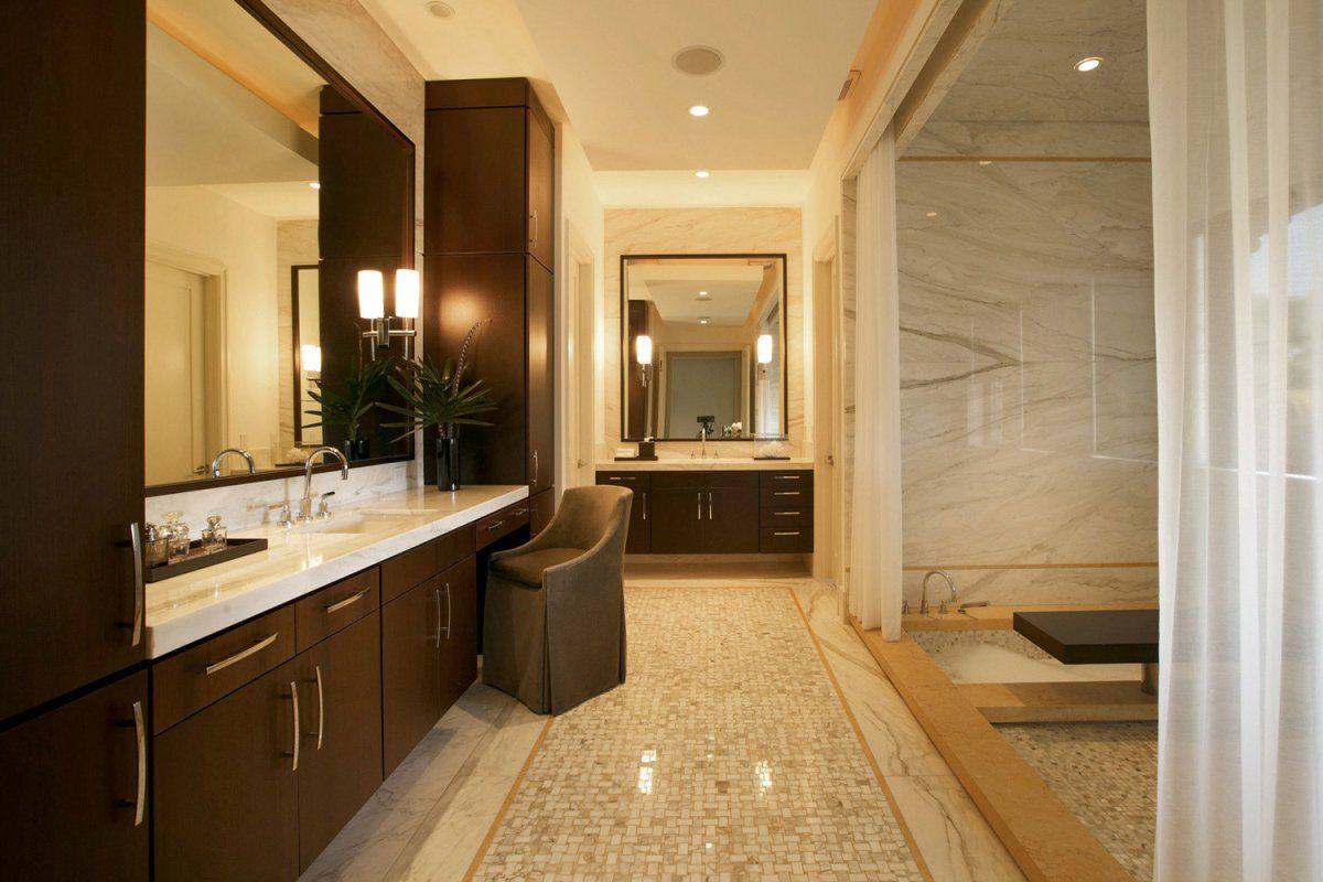 Luxury bathroom with dark wood cabinets, marble countertops, and a large soaking tub.