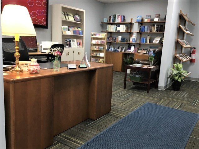 A room with a desk and shelves full of books