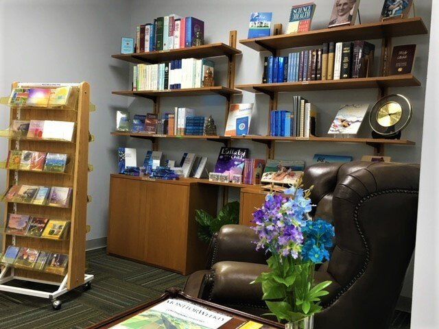 A living room with a chair and a shelf full of books