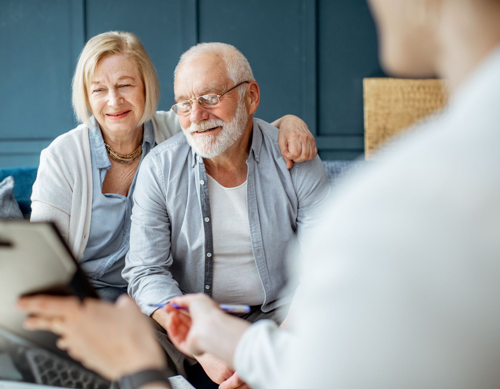 An older couple admiring a clipboard that someone is holding